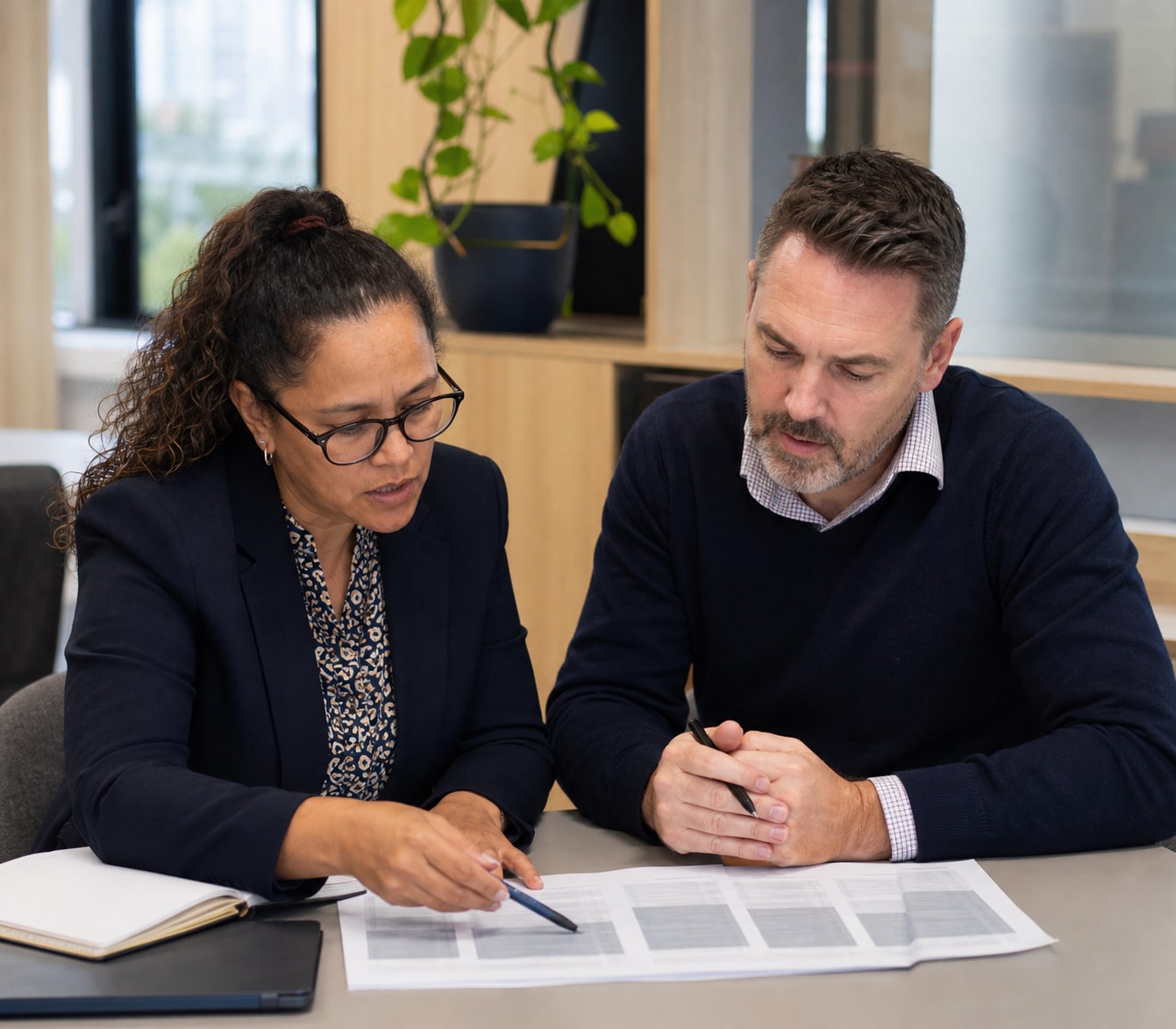 Two public-sector professionals reading across the full set of work-level requirements.