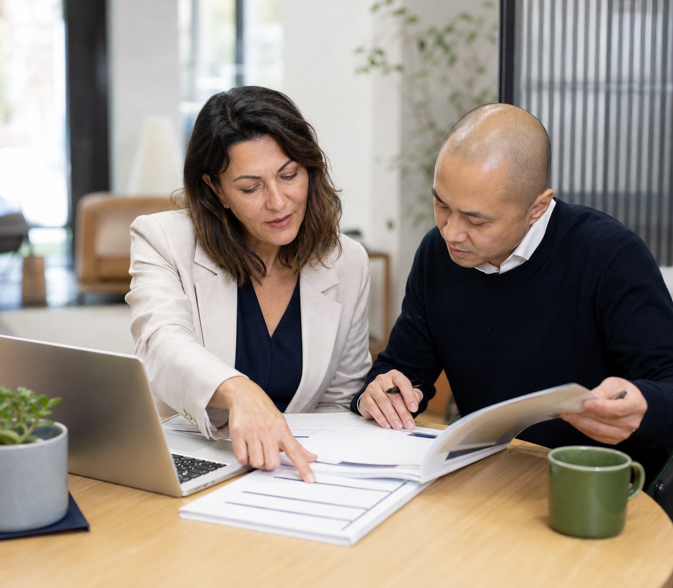Career adviser and applicant checking candidate-pack instructions against an application checklist.